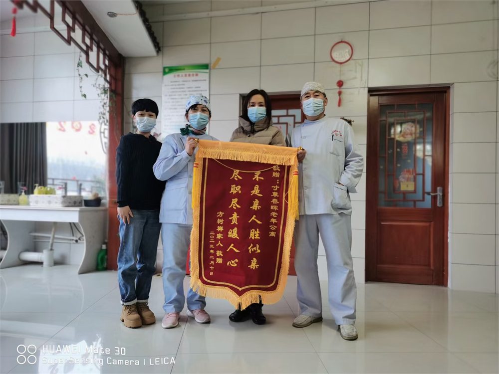 邹城市寸草春晖老年公寓锦旗合影